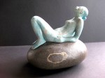 Woman (ceramic) sitting on natural stone