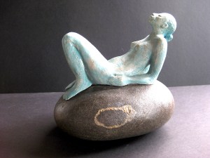 Woman (ceramic) sitting on natural stone